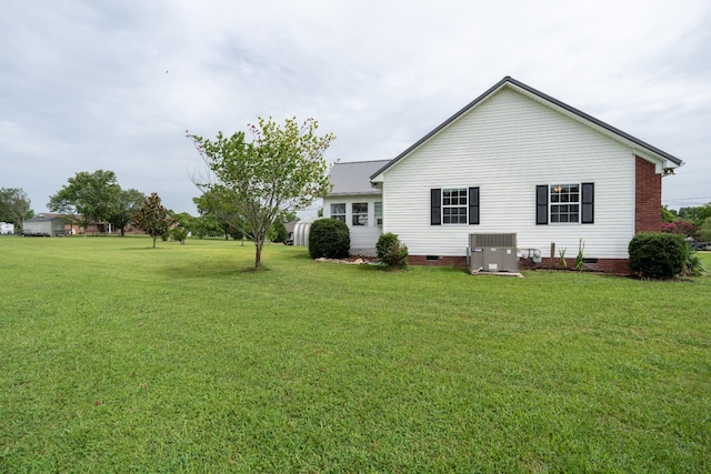 back of house with a lawn and central air condition unit