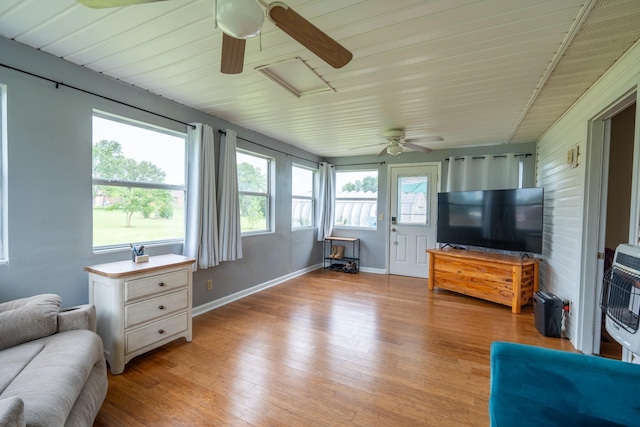 living room with light hardwood / wood-style floors, heating unit, and ceiling fan