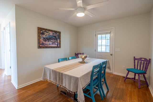 dining space with ceiling fan and dark wood-type flooring