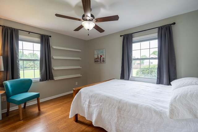 bedroom featuring wood-type flooring, multiple windows, and ceiling fan