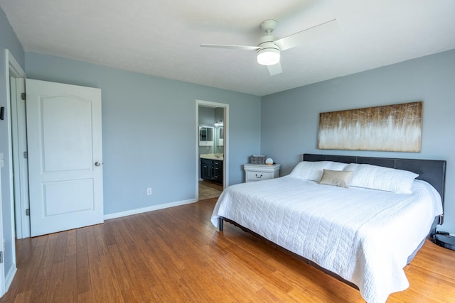 bedroom featuring ensuite bath, ceiling fan, and hardwood / wood-style flooring