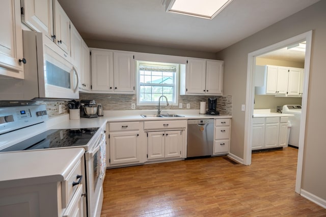 kitchen featuring sink, white cabinets, light hardwood / wood-style floors, and white appliances