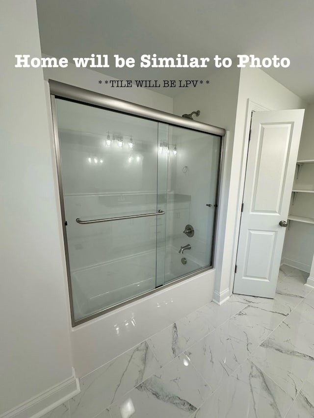 bathroom with bath / shower combo with glass door