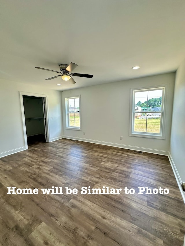 empty room featuring dark wood-type flooring and ceiling fan