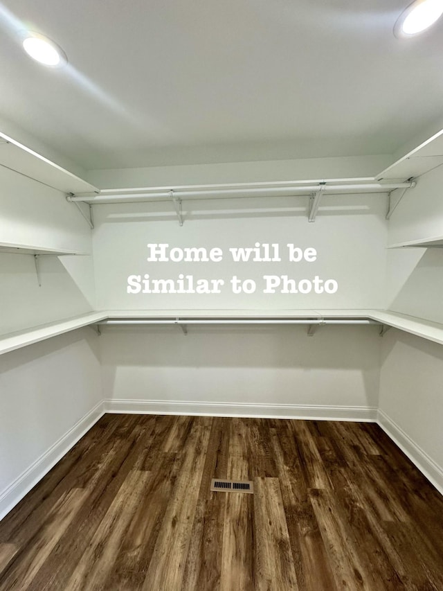 spacious closet with dark hardwood / wood-style floors