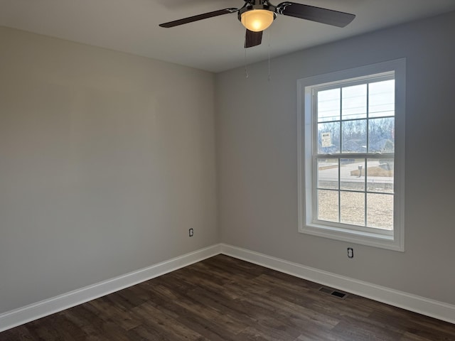 empty room with dark hardwood / wood-style floors and ceiling fan