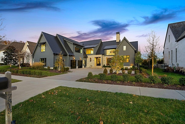 modern farmhouse style home featuring a lawn and a garage