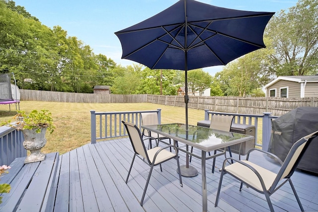 wooden terrace featuring a grill and a yard