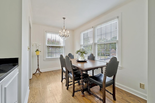 dining space with light hardwood / wood-style flooring and an inviting chandelier