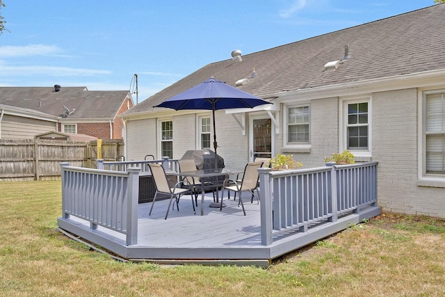 wooden deck with a lawn and area for grilling