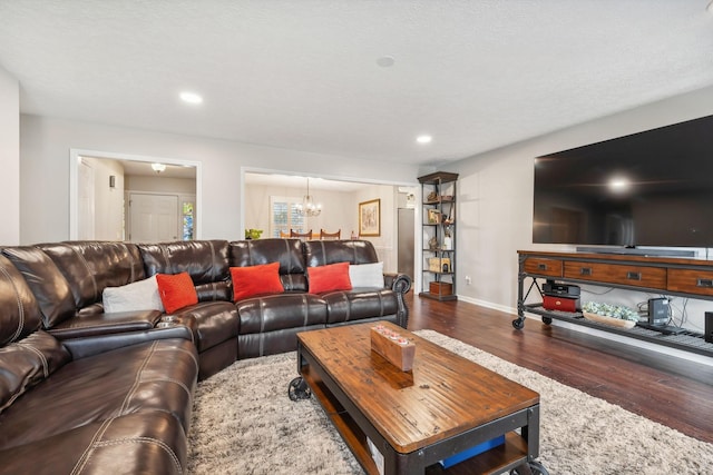 living room with wood-type flooring, a textured ceiling, and a notable chandelier