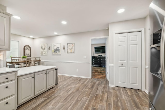 kitchen featuring hardwood / wood-style flooring and stainless steel fridge with ice dispenser