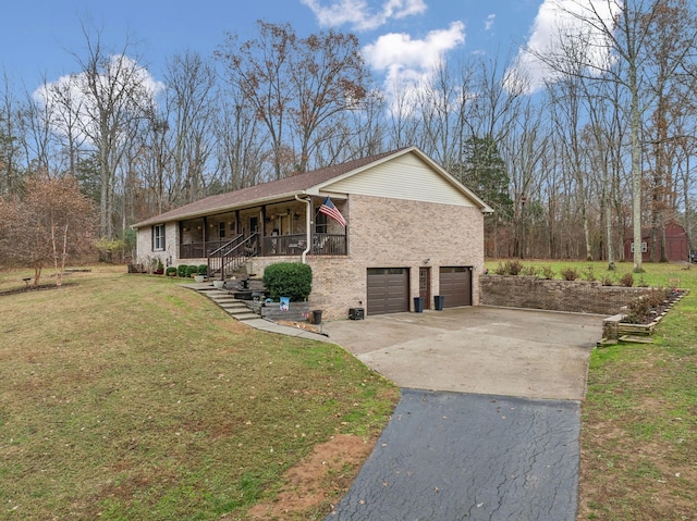 view of front of property featuring a garage, covered porch, and a front lawn