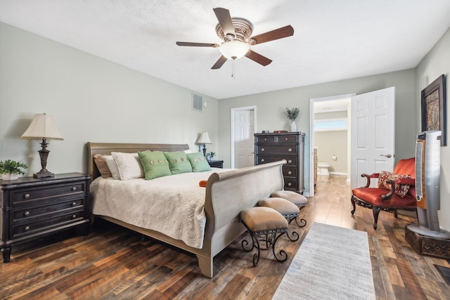 bedroom with dark hardwood / wood-style flooring, ensuite bathroom, and ceiling fan