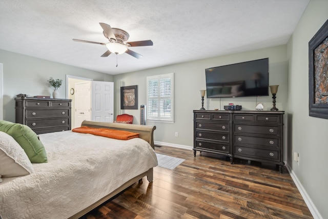 bedroom with ceiling fan, dark hardwood / wood-style flooring, and a textured ceiling