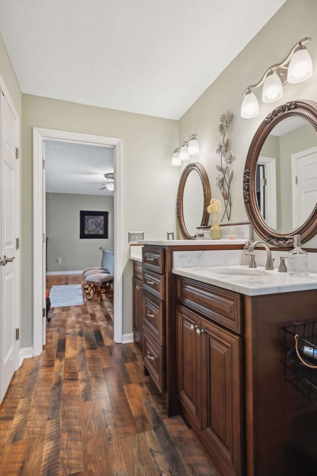 bathroom featuring wood-type flooring, vanity, and ceiling fan