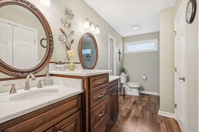 bathroom featuring wood-type flooring, vanity, and toilet