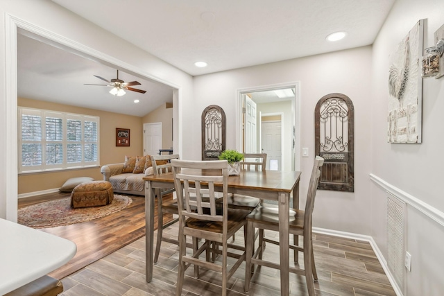 dining area featuring ceiling fan, wood-type flooring, and lofted ceiling