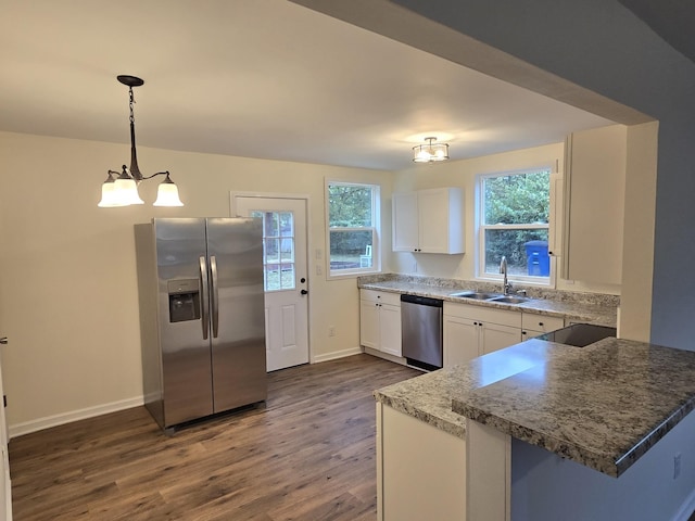 kitchen with stainless steel appliances, sink, decorative light fixtures, an inviting chandelier, and white cabinetry