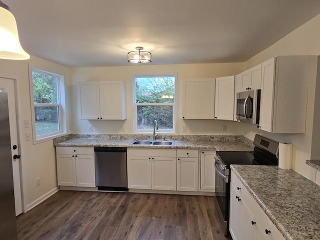 kitchen featuring a wealth of natural light, sink, dark hardwood / wood-style floors, white cabinets, and appliances with stainless steel finishes