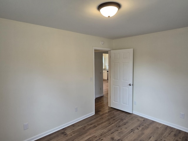 spare room with dark wood-type flooring