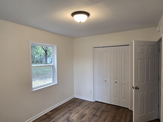 unfurnished bedroom featuring dark wood-type flooring and a closet