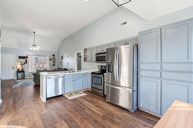 kitchen with ceiling fan, dark hardwood / wood-style flooring, kitchen peninsula, and appliances with stainless steel finishes