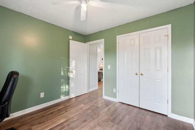 unfurnished office with ceiling fan, a textured ceiling, and hardwood / wood-style flooring