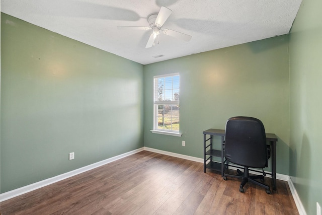 home office featuring ceiling fan, dark wood-type flooring, and a textured ceiling