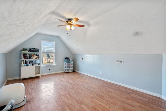 bonus room featuring a textured ceiling, ceiling fan, vaulted ceiling, and hardwood / wood-style flooring