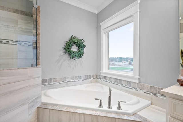 bathroom with tiled tub, crown molding, and vanity