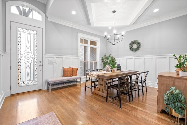 dining area featuring a chandelier, beam ceiling, light hardwood / wood-style flooring, and crown molding