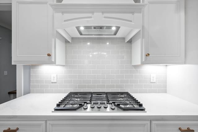 kitchen with decorative backsplash, white cabinetry, and stainless steel gas cooktop