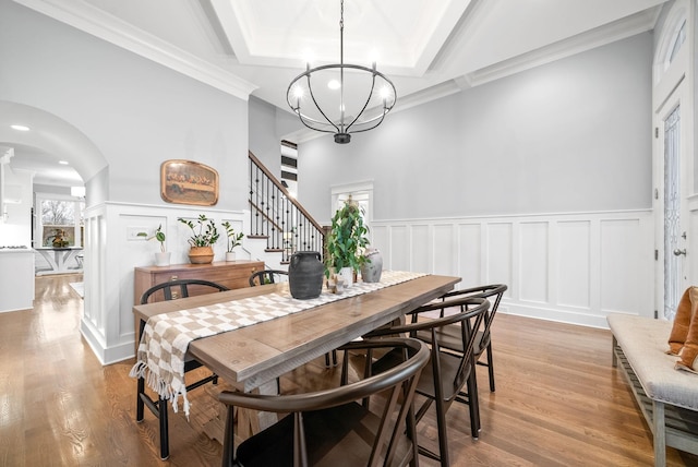 dining space with an inviting chandelier, light hardwood / wood-style flooring, and crown molding