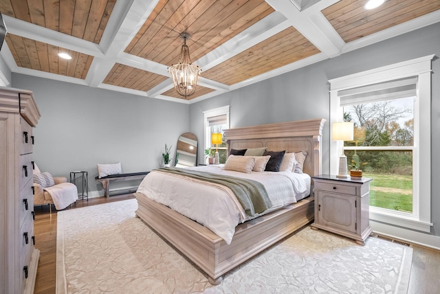 bedroom featuring multiple windows, light hardwood / wood-style flooring, and wood ceiling