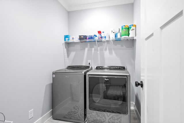 clothes washing area featuring washer and dryer and ornamental molding