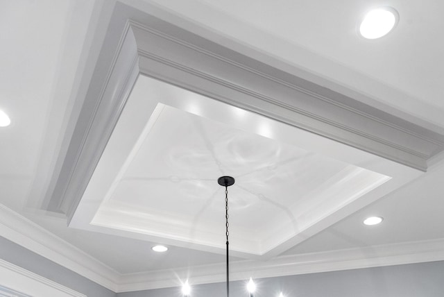 interior details with a tray ceiling and ornamental molding