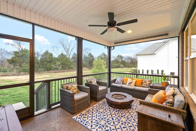 sunroom / solarium with ceiling fan, plenty of natural light, and wood ceiling