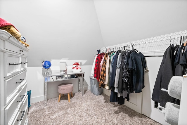 walk in closet featuring light carpet and vaulted ceiling