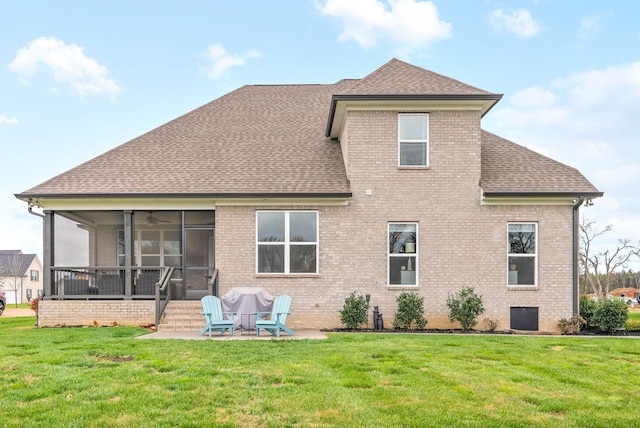 rear view of house featuring a sunroom, a patio area, and a lawn