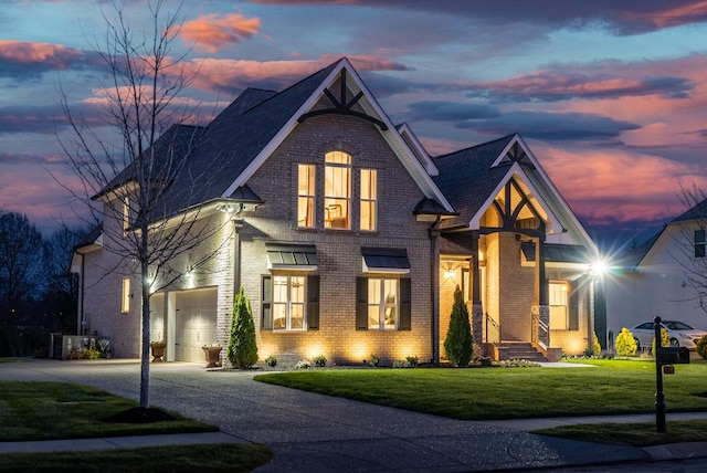 view of front of home featuring a lawn, central AC unit, and a garage