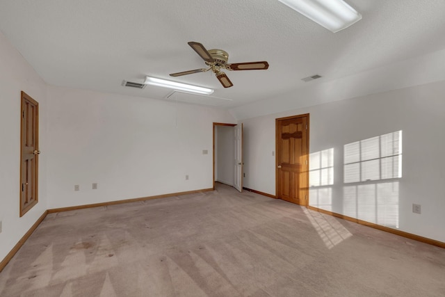 carpeted empty room with ceiling fan and a textured ceiling