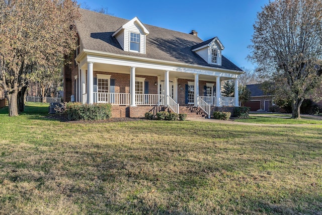 cape cod home featuring a porch and a front lawn