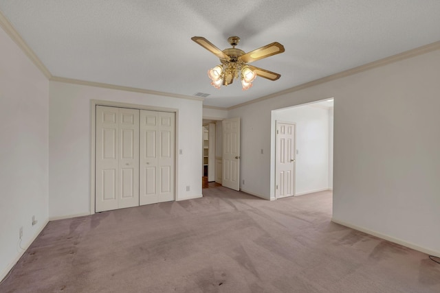 unfurnished bedroom featuring ceiling fan, a closet, light carpet, and ornamental molding