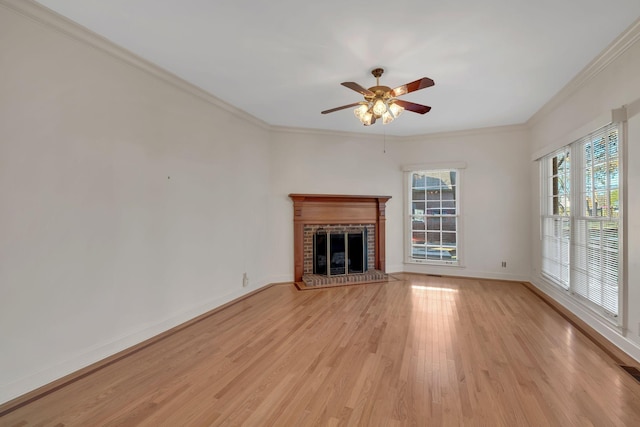 unfurnished living room featuring a brick fireplace, crown molding, and light hardwood / wood-style flooring