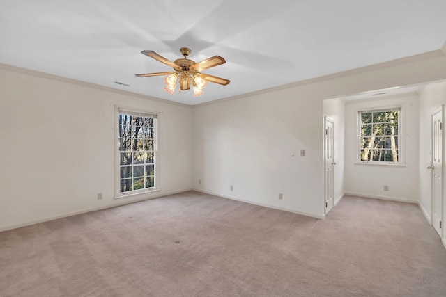 carpeted spare room with ceiling fan and crown molding