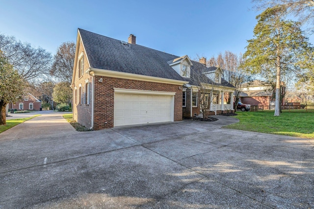 view of side of property featuring a garage and a lawn