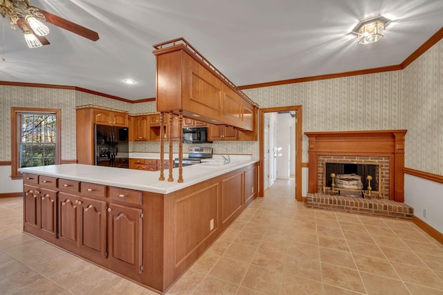 kitchen with kitchen peninsula, ornamental molding, ceiling fan, black appliances, and a fireplace