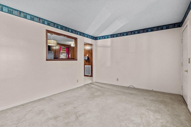 carpeted empty room with a textured ceiling