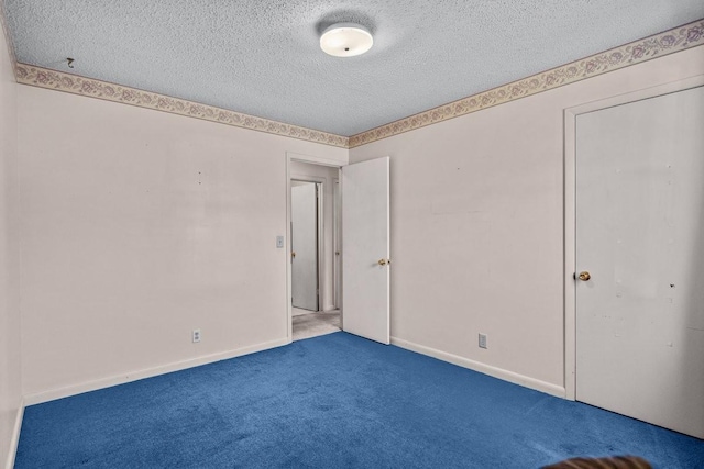 unfurnished room with carpet and a textured ceiling